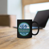 Black mug with Colorado road trip logo sitting on a table